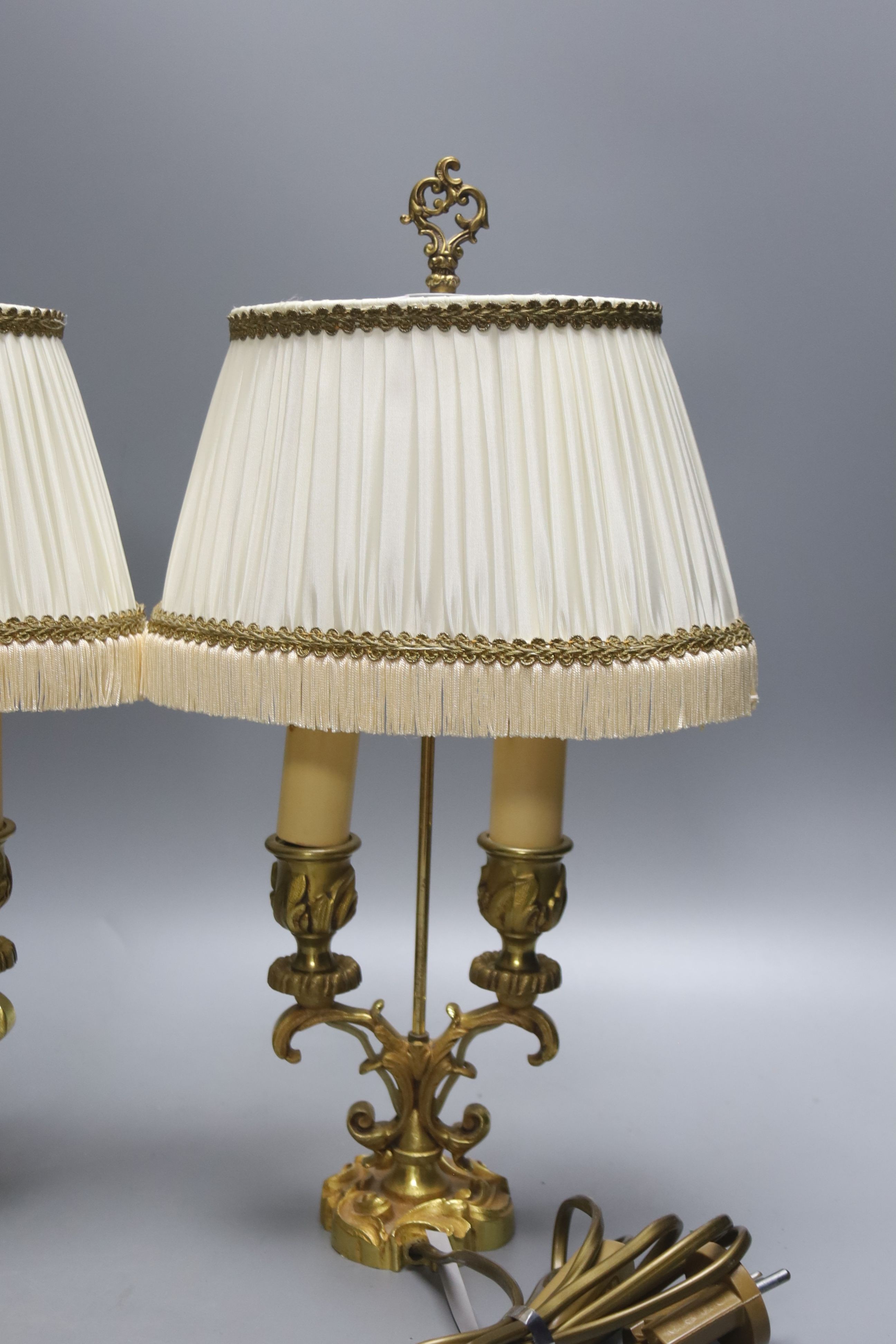 A pair of 19th century brass three branch candlesticks and a pair of twin branch table lamps, tallest 40cm